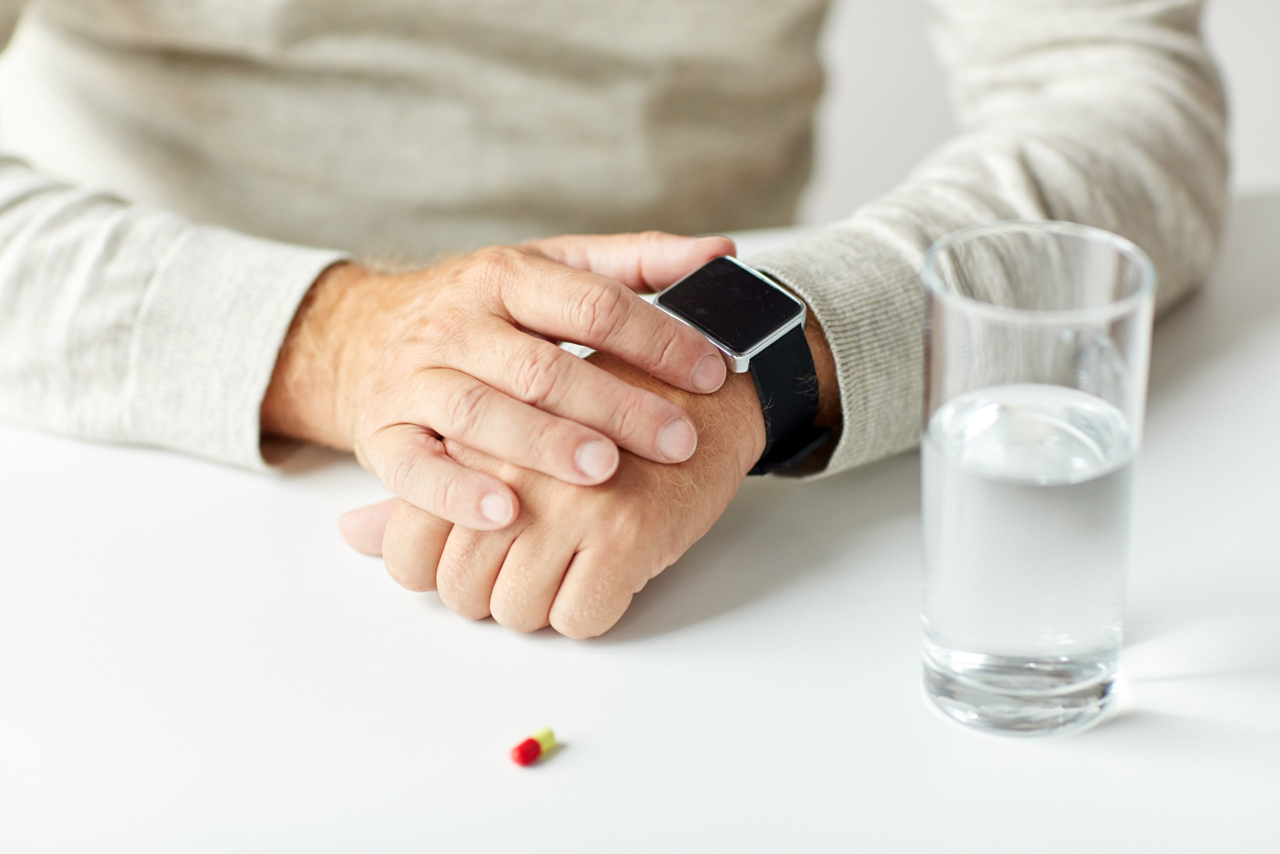 An elderly man receives a reminder to take medication on his smartwatch. 