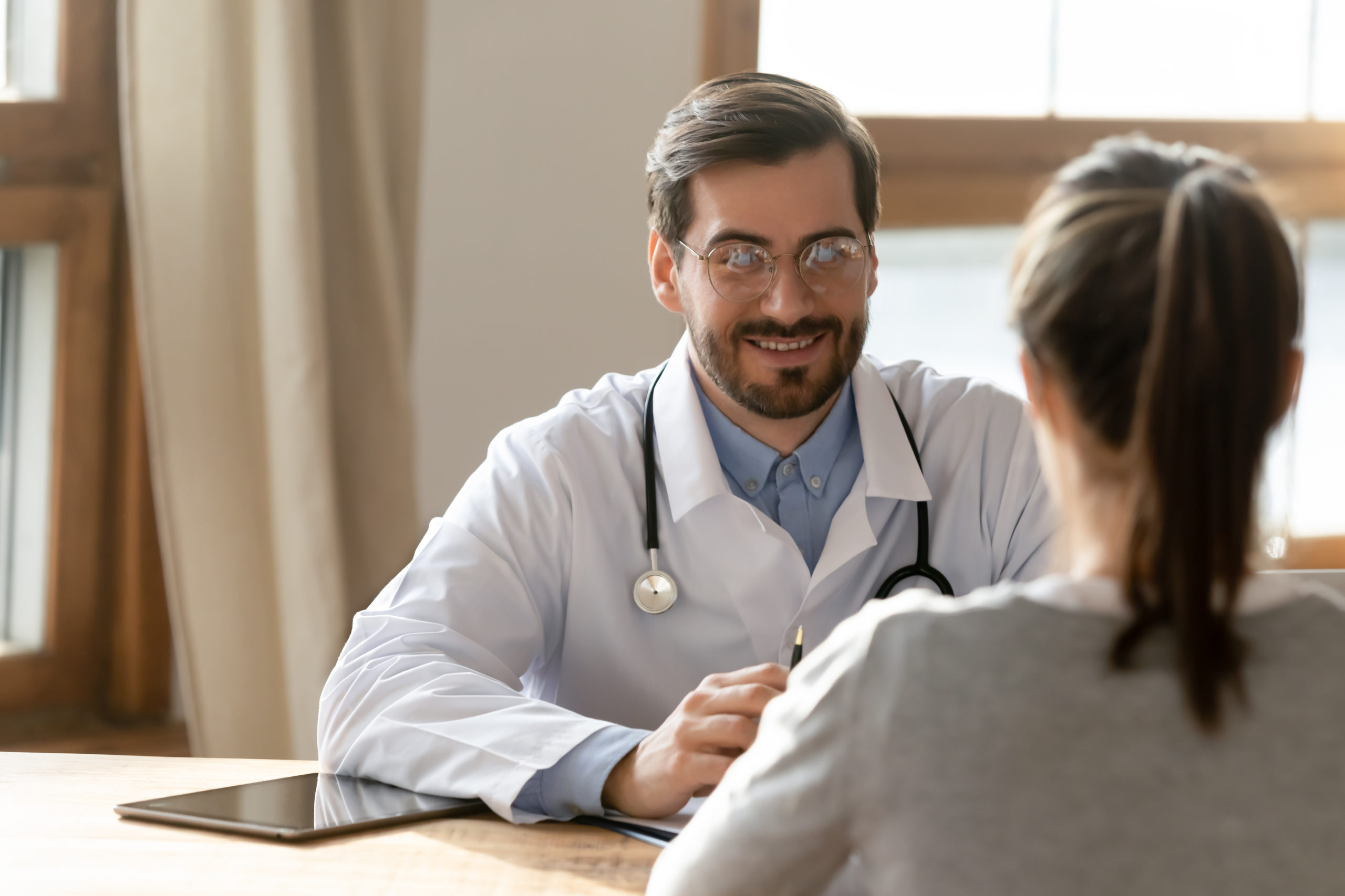  A woman and her doctor discuss her health during an in-person visit.