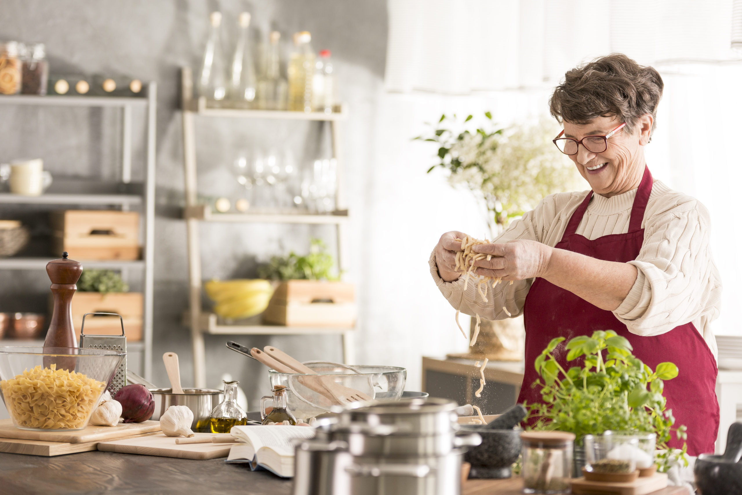  While cooking in the kitchen alone, a woman feels safe knowing her fall detection alert system will protect her. 