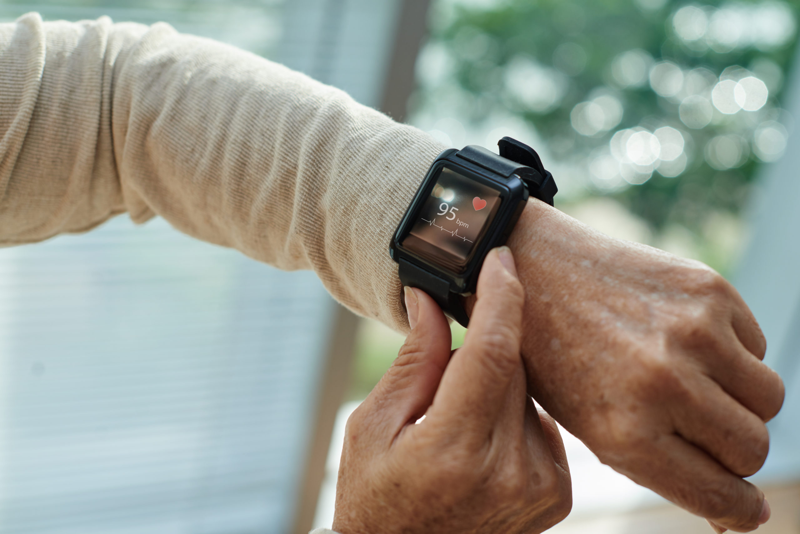  Senior woman checks her heart rate on a smartwatch. 