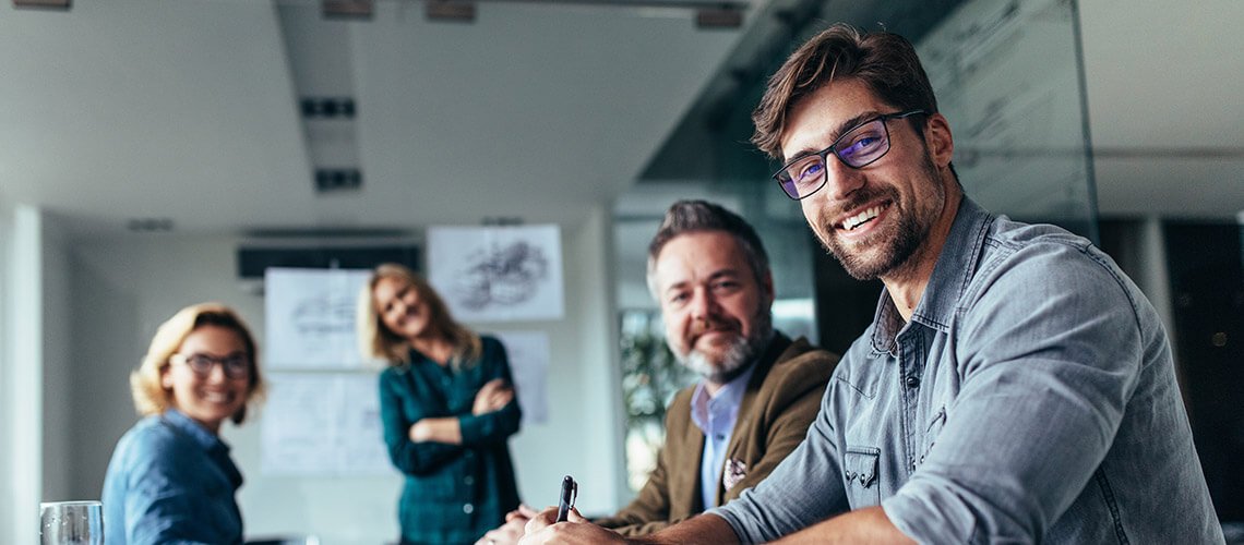 Business people around a table, smiling and being productive.