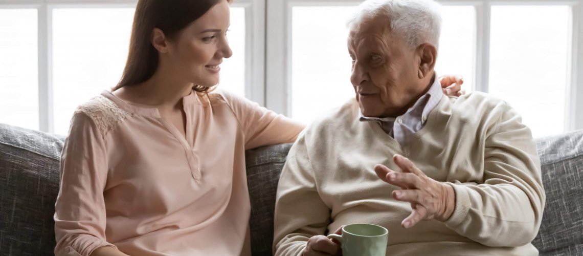 Daughter talking to her senior citizen father over a cup of tea.